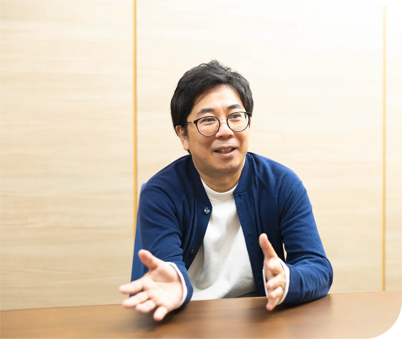 テーブルで身振り手振りを交えて話すT.H