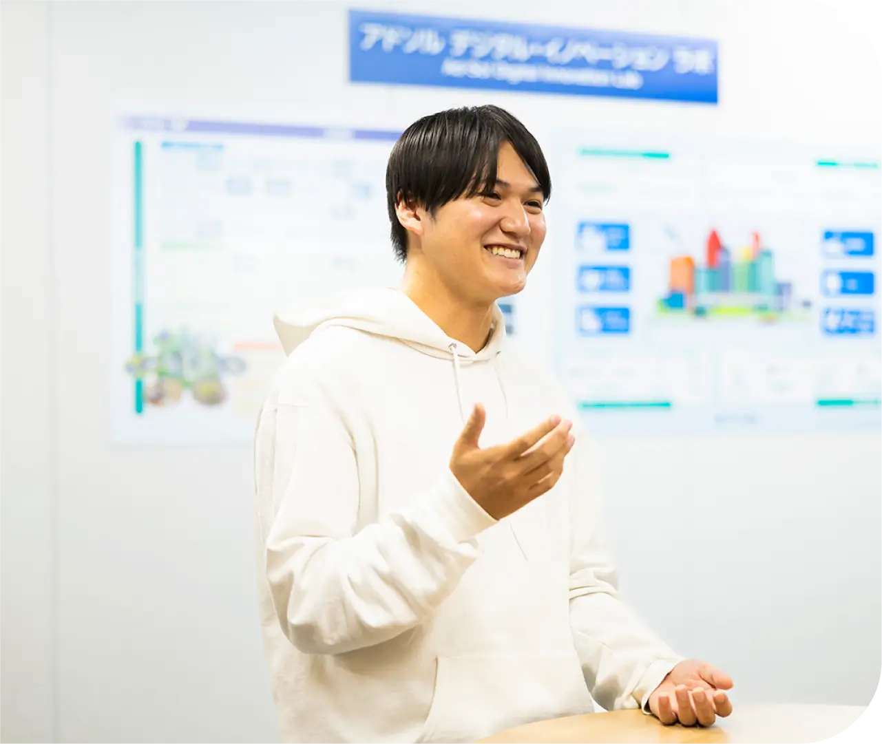 デジタルイノベーションラボの前で身振りを交えて話すK.Y