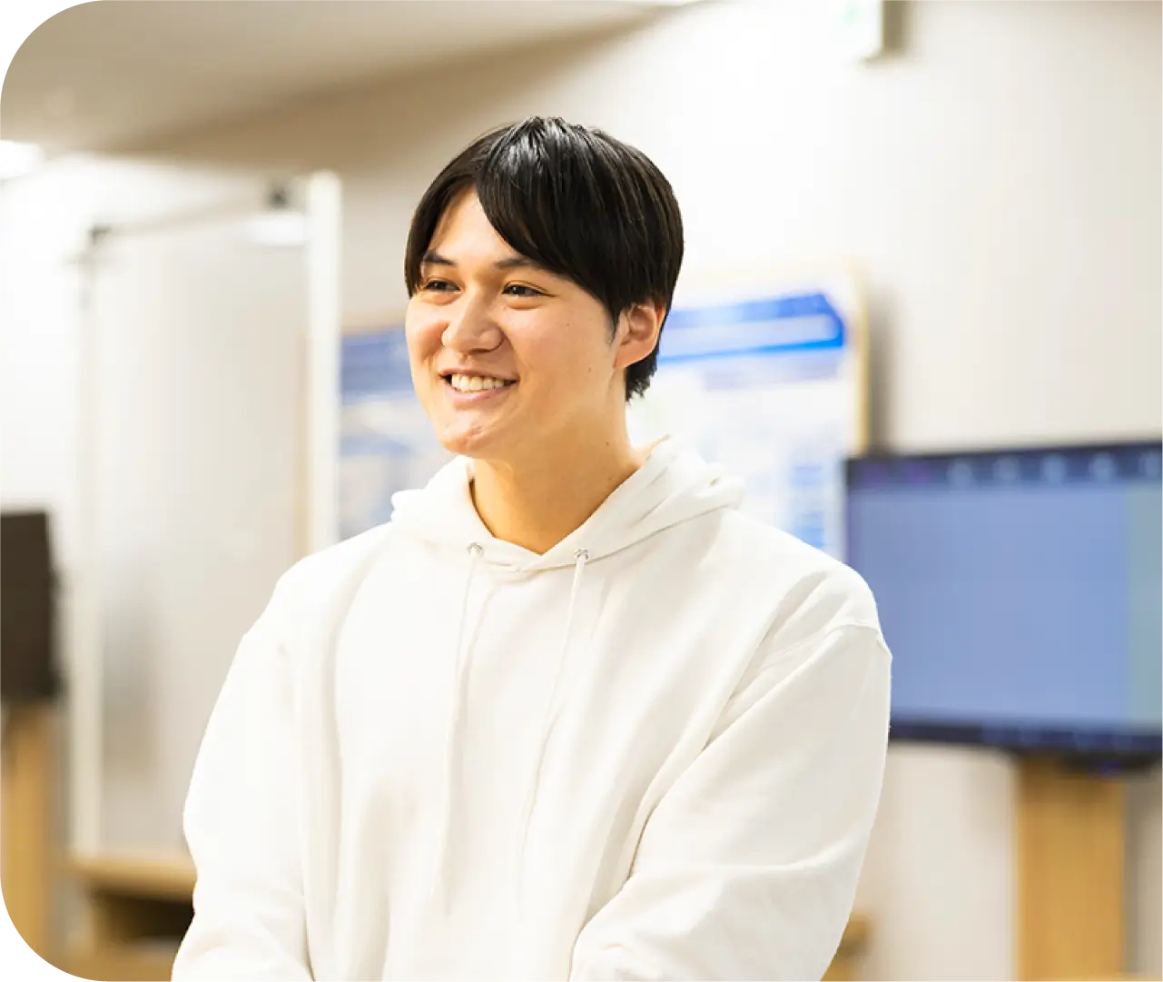 オフィスで穏やかに微笑むK.Y