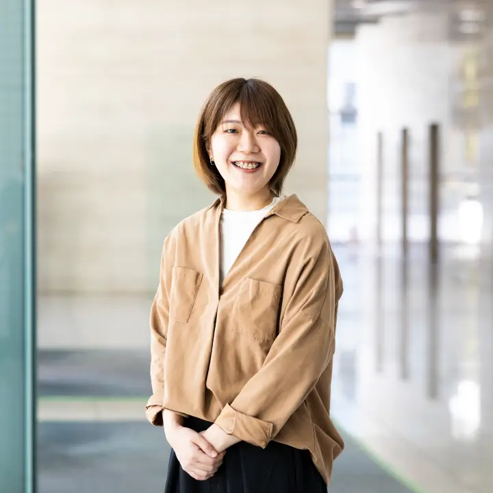 オフィスの廊下で笑顔のS.H