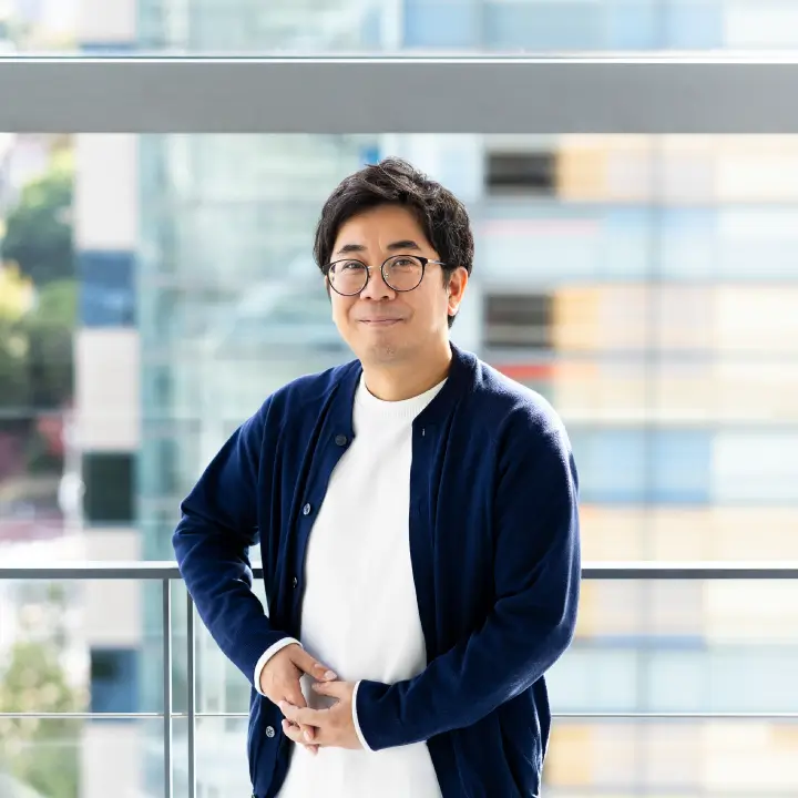 窓辺に立ち笑顔のT.H