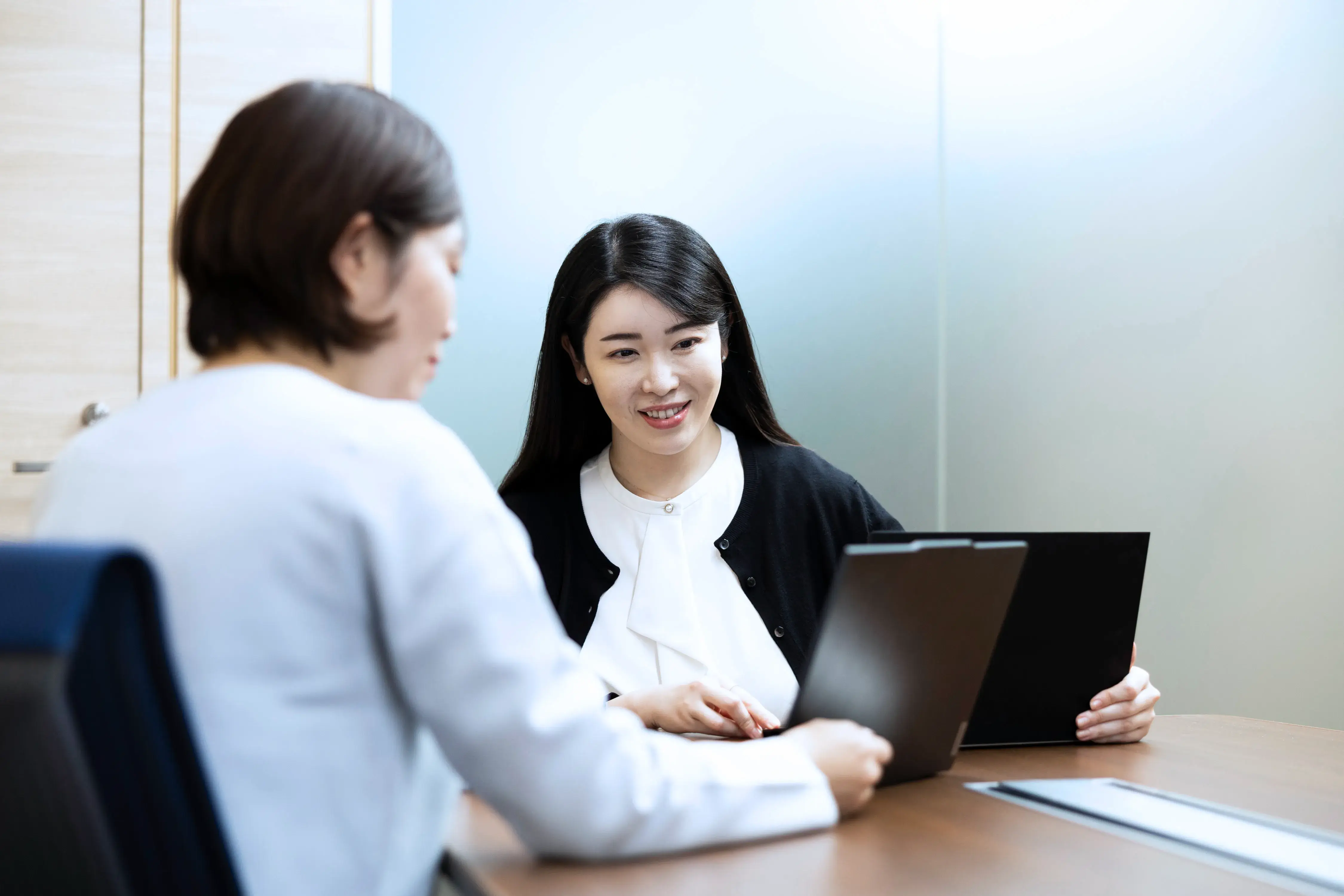 ノートPCを前に打ち合わせをする女性社員